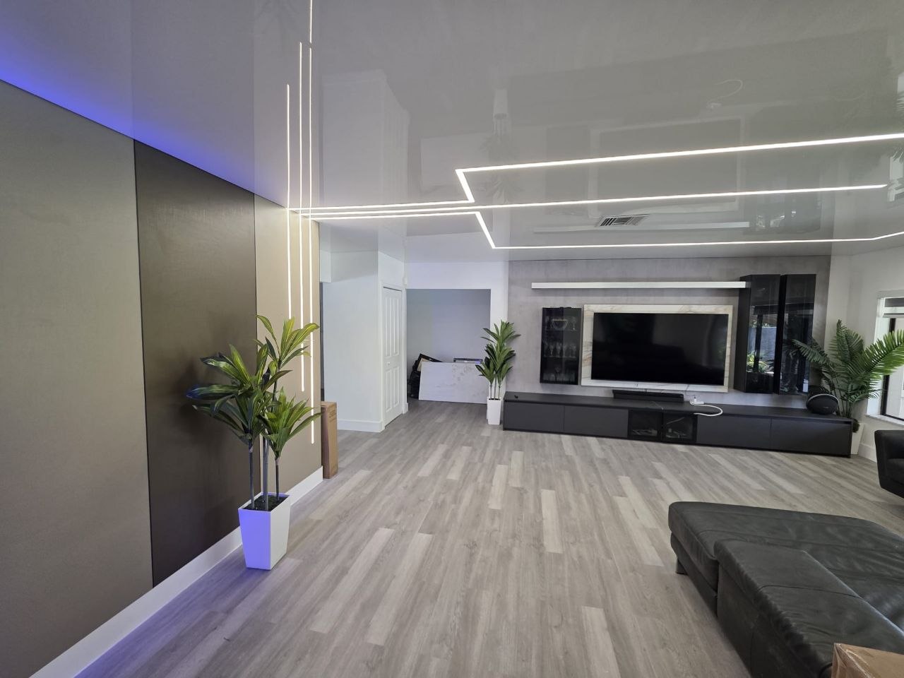 Gloss stretch ceiling with recessed light lines in a Miami living room